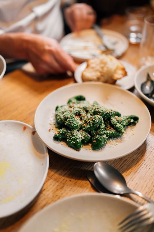 Free Delicious spinach gnocchi served on a modern dining table setting. Ideal for food lovers. Stock Photo