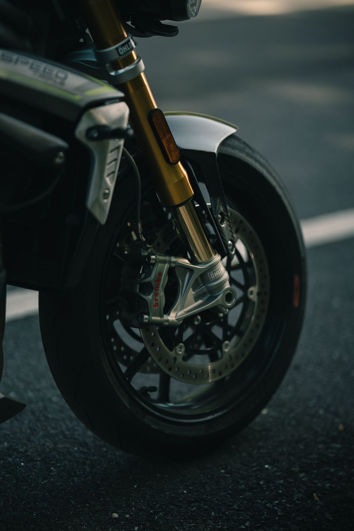 Close up of motorcycle front tire on cracked asphalt