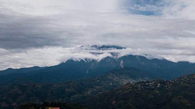 云层覆盖着山峰，山脉的壮丽景色营造出一片宁静的景观
