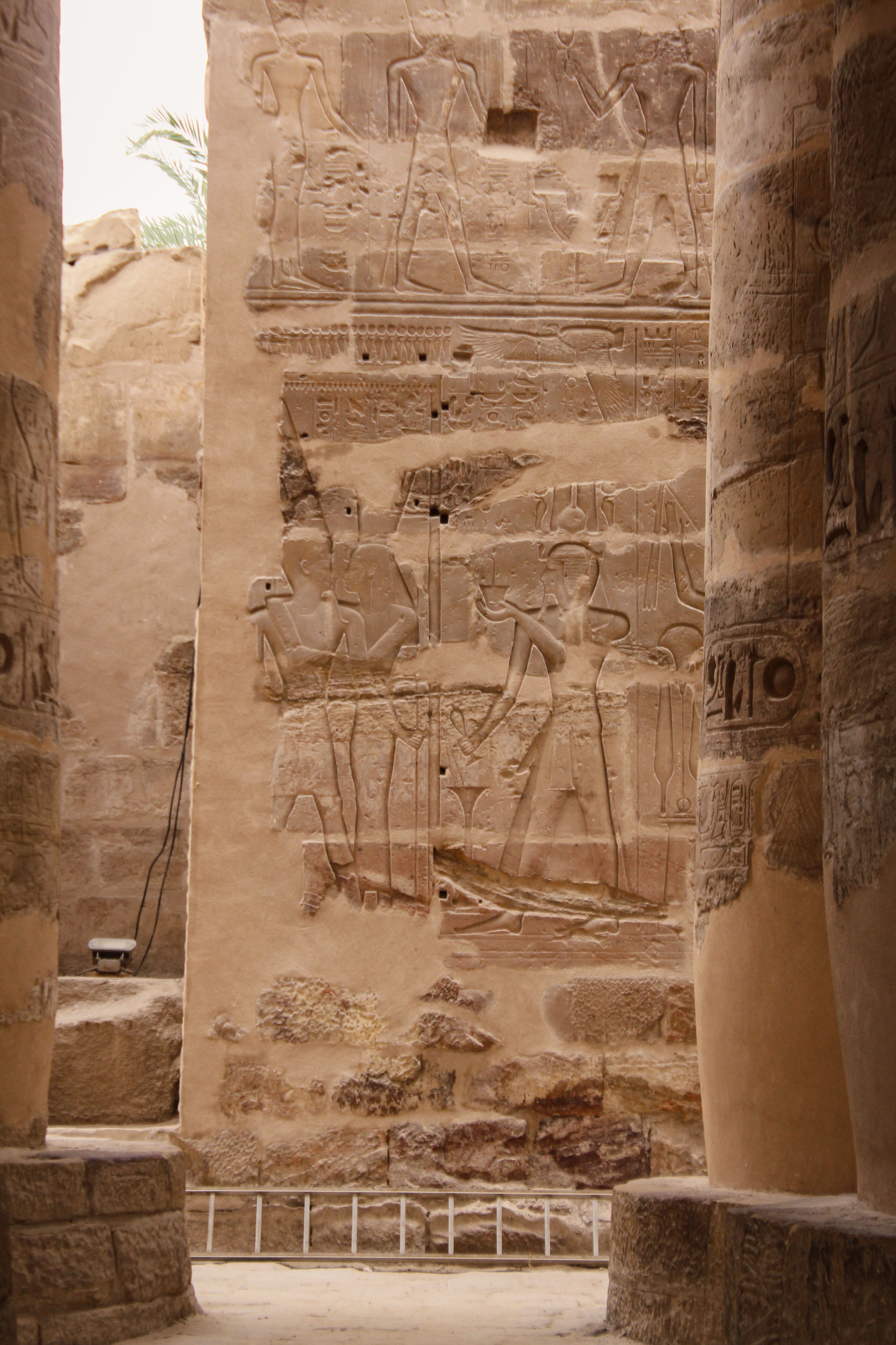 Intricate stone carvings on ancient temple walls in Luxor, Egypt, showcasing historical Egyptian art.