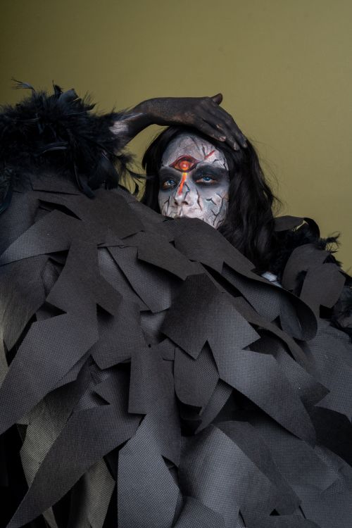 Free A haunting figure with elaborate horror-themed makeup and dark feathered costume. Stock Photo