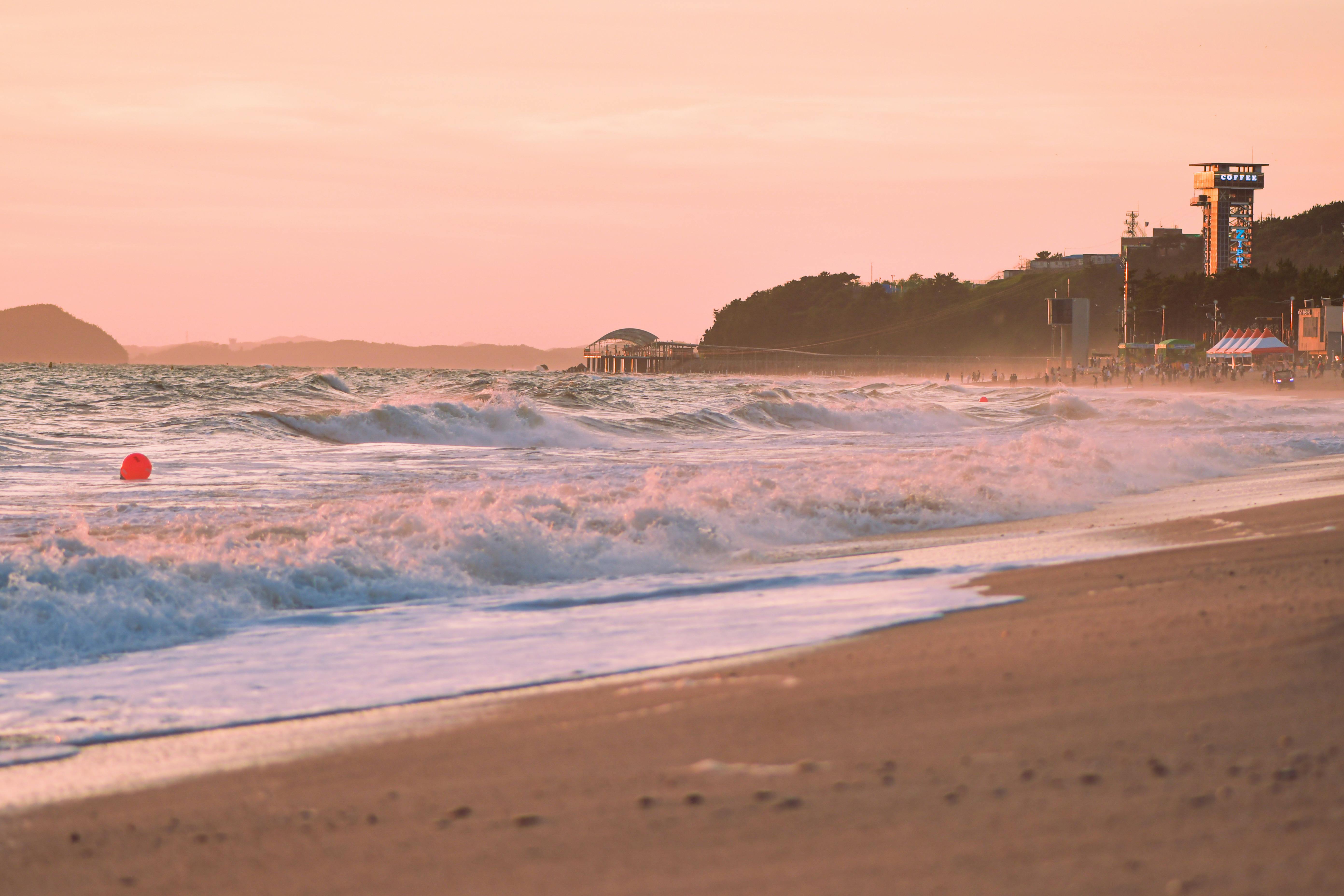 Beautiful beach scene with soft waves and sunset sky, perfect for travel inspiration.