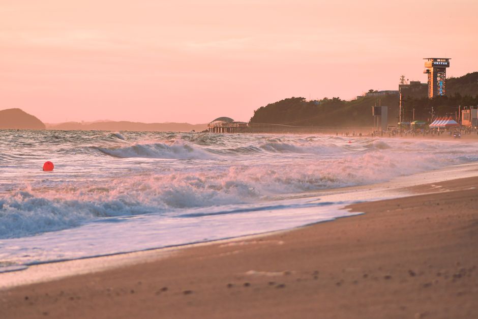 Beautiful beach scene with soft waves and sunset sky, perfect for travel inspiration.