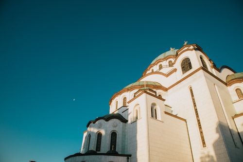 Free St. Sava Temple in Belgrade with clear blue sky and crescent moon. Stock Photo