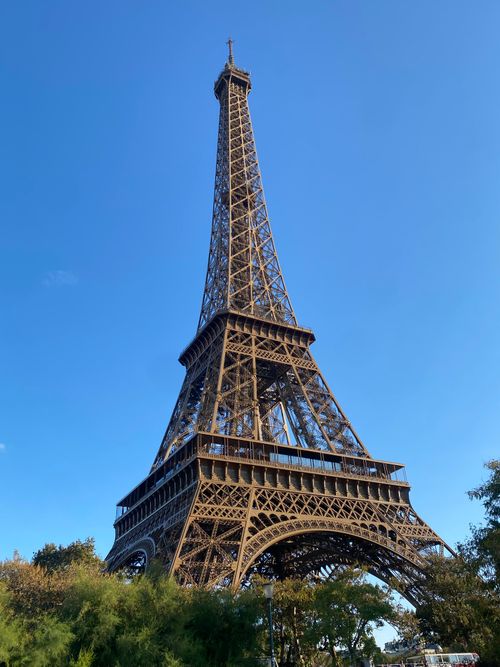 Free View of the Eiffel Tower against a bright blue sky in Paris, France. Stock Photo