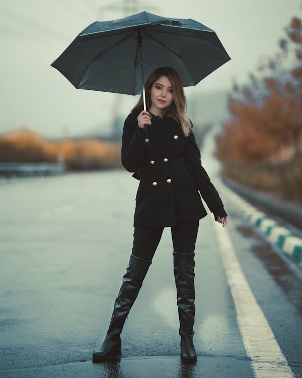 Woman Standing On A  Road Holding An Umbrella