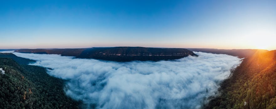 探索云雾缭绕的山脉和茂密森林中令人惊叹的日出全景