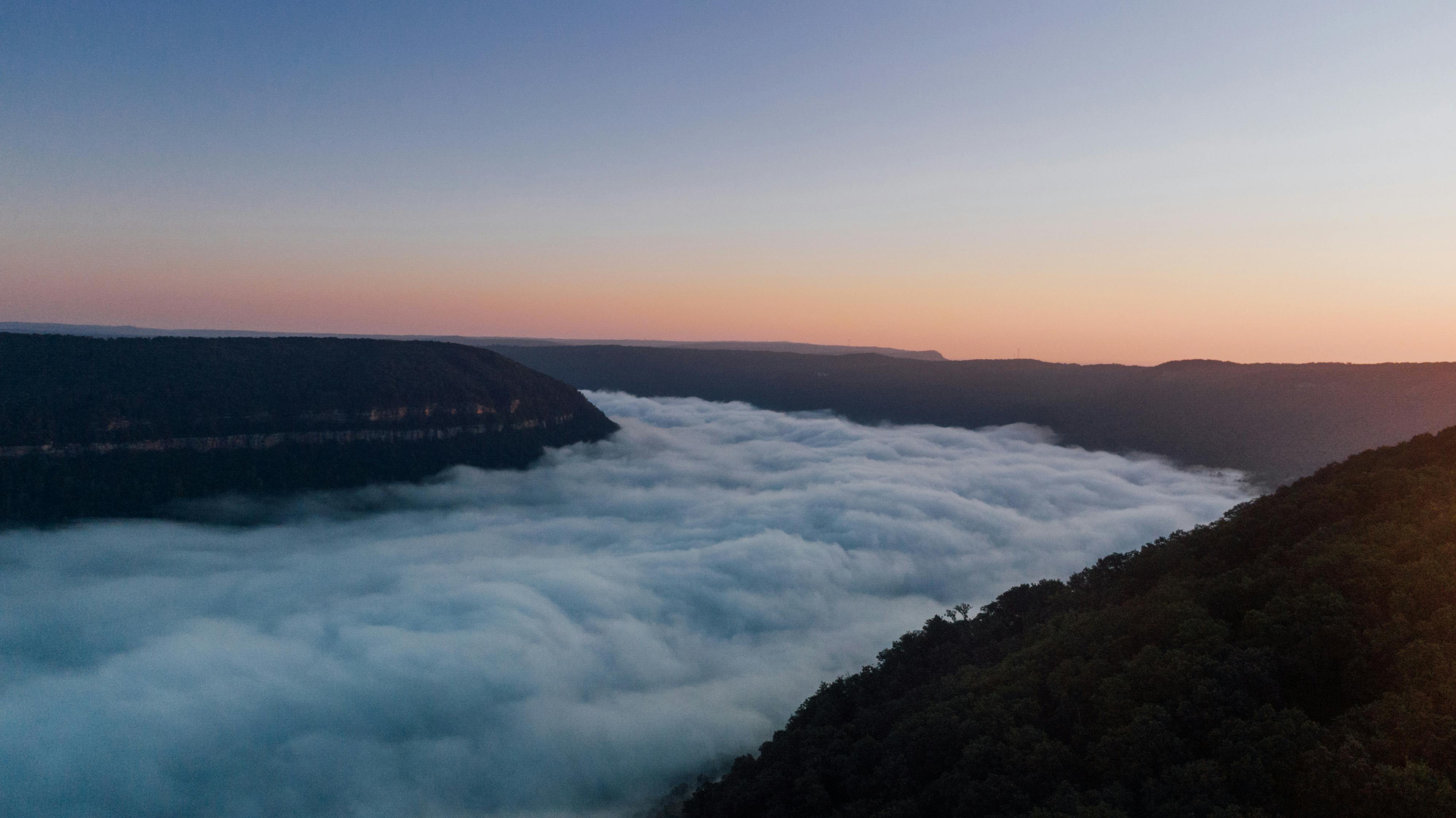 日落时分，薄雾笼罩山脉，景色壮丽，营造出宁静而迷人的景象