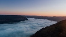 日落时分，薄雾笼罩山脉，景色壮丽，营造出宁静而迷人的景象