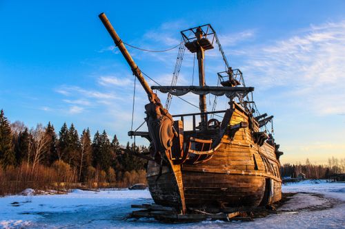 Free An old wooden pirate ship stands in a snowy winter landscape during the day. Stock Photo