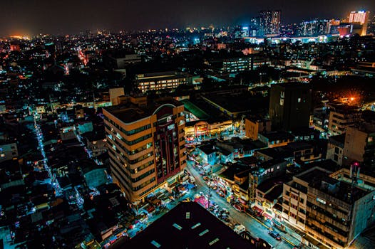 从空中俯瞰，繁华的城市夜景灯火通明，街道与建筑清晰可见