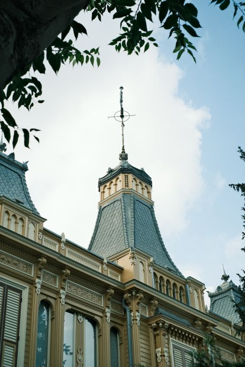 Free Victorian era rooftop featuring ornate turrets and detailed architecture against a blue sky. Stock Photo