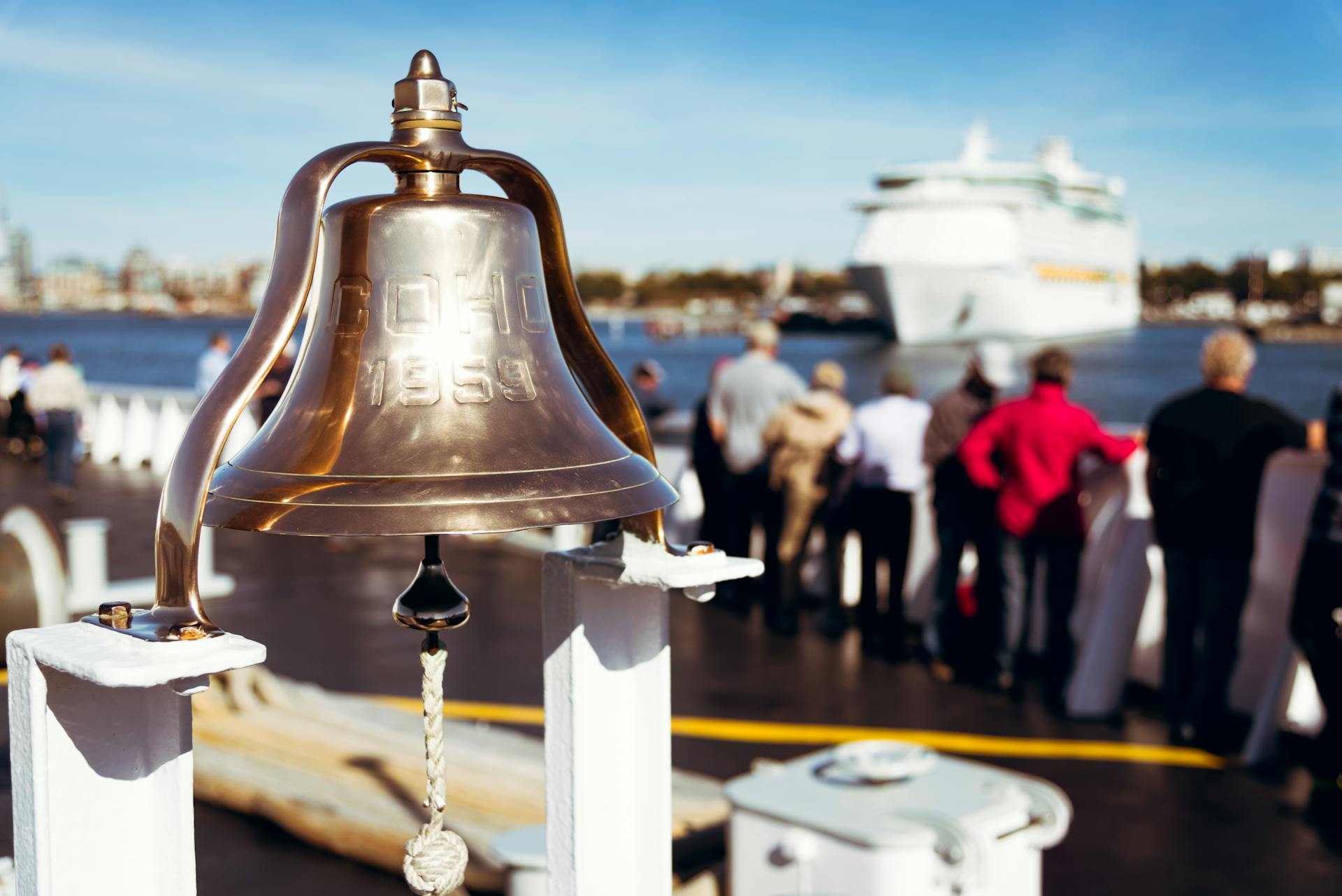 Brass bell on a ferry with people leaving Canada to USA