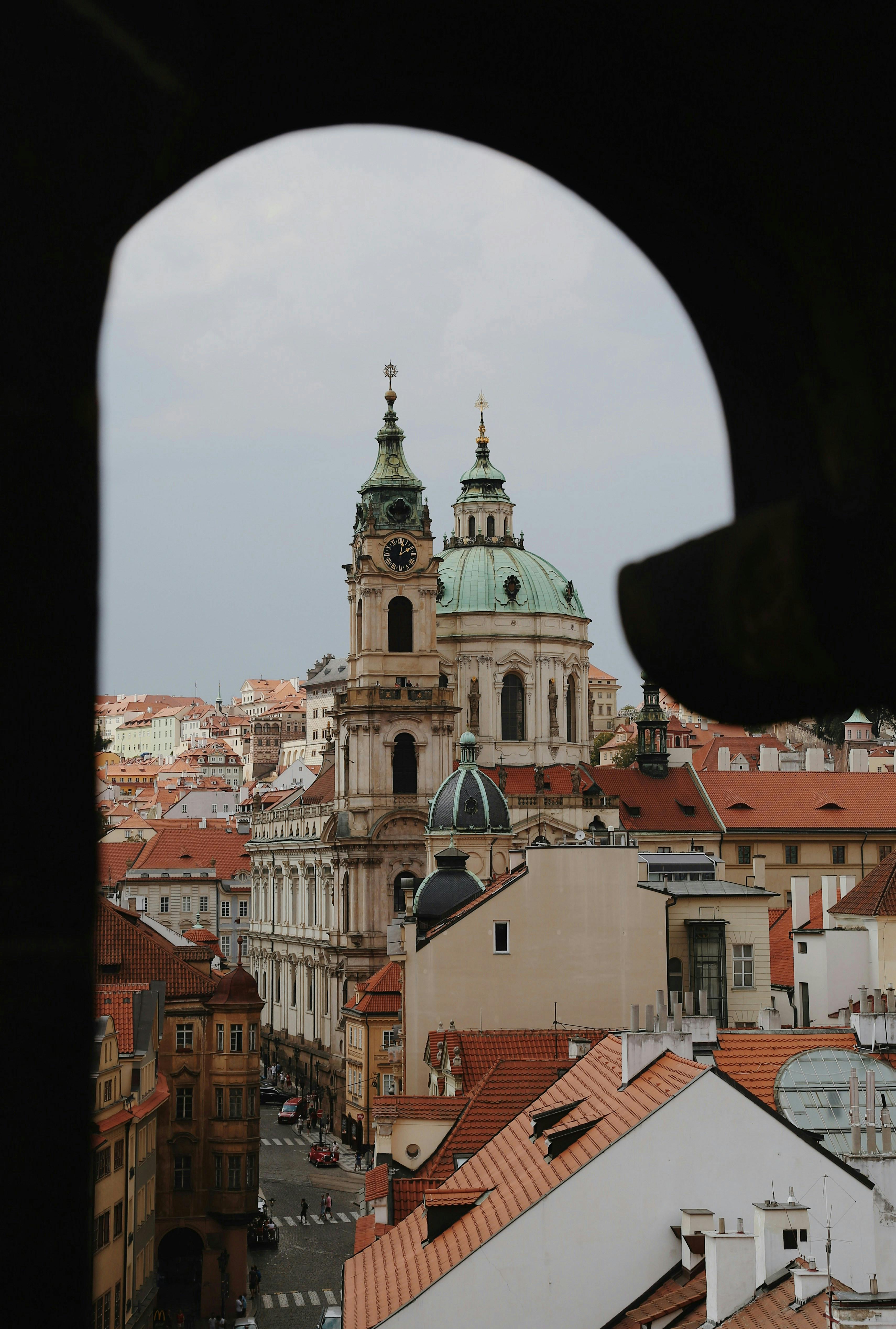 Beautiful view of historic church and buildings in Prague framed by an arch.