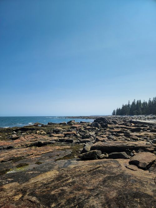 Free Explore the rugged rocky shoreline with clear blue skies and picturesque ocean views. Stock Photo