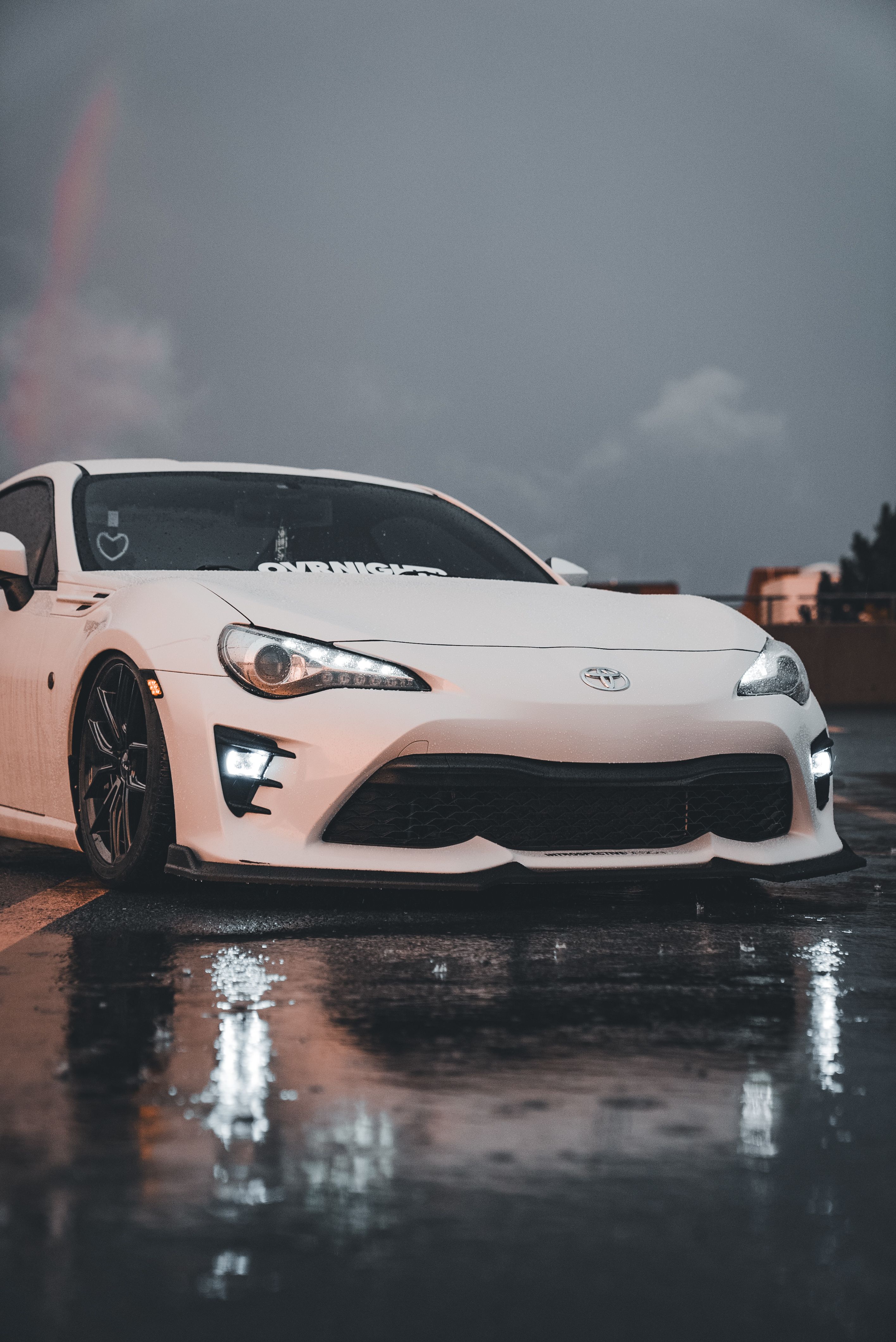 Sleek White Sports Car on Wet Asphalt at Dusk · Free Stock Photo