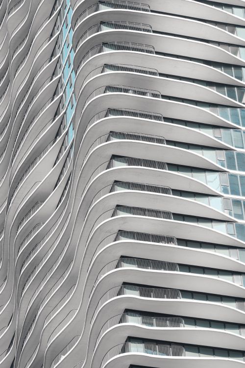 Free Close-up of a modern skyscraper with a unique wavy facade design. Stock Photo