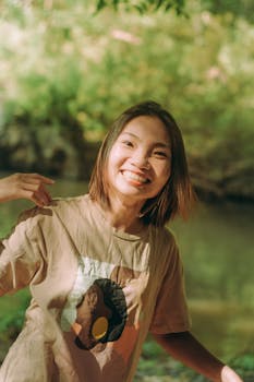 一位快乐的女子在阳光明媚的户外自然环境中微笑，洋溢着喜悦与积极