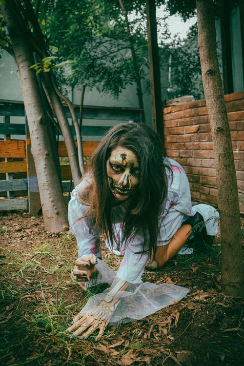 Free Scary zombie in costume crawling outdoors, perfect for Halloween themes. Stock Photo