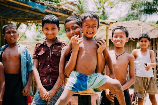 A group of happy young boys playing together outdoors on a sunny day.