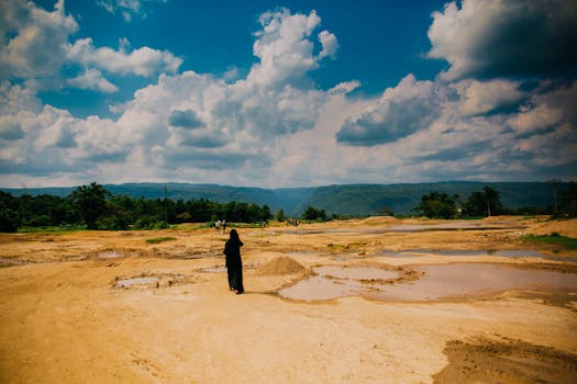 阴沉的天空下，一个孤独的身影出现在宁静的沙漠中，展现了大自然的广阔