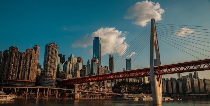 Stunning view of Chongqing's skyscrapers and the Yangtze River Bridge under a blue sky.