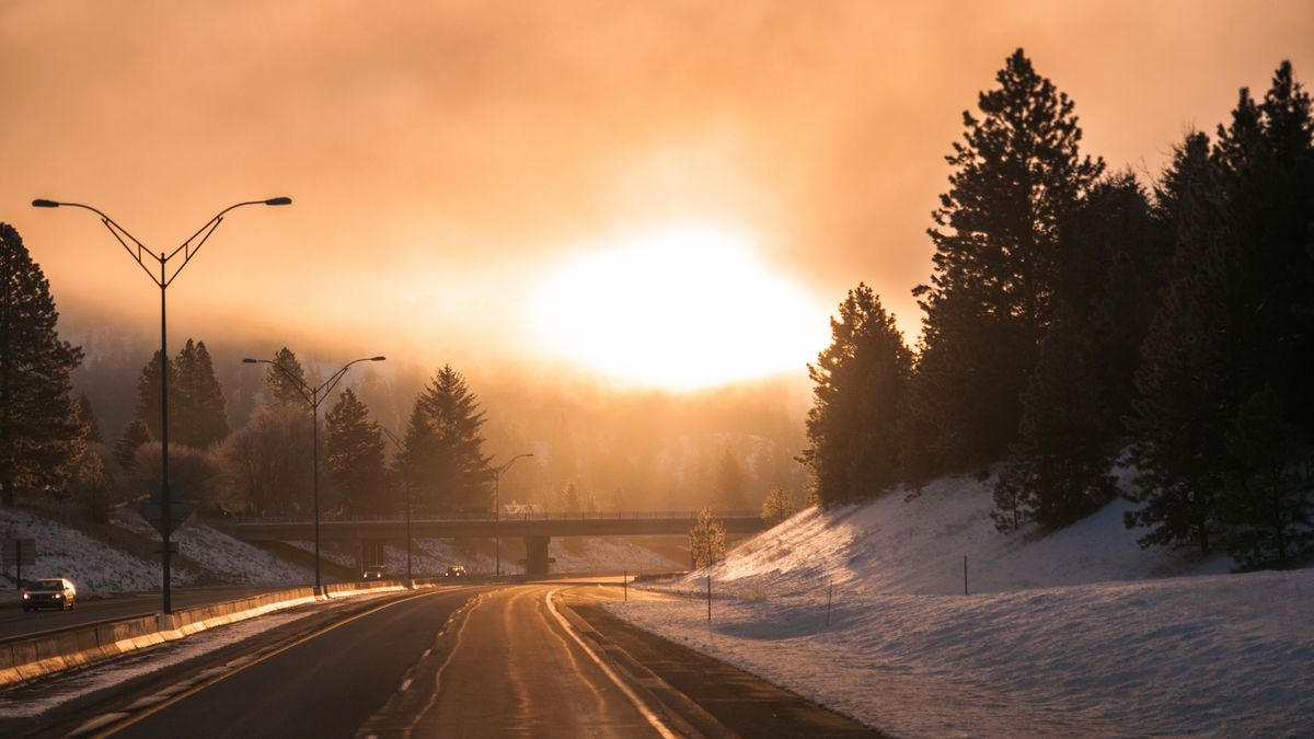 Photo: dumitru bumbu / Pexels A quiet winter road at sunrise with warm light on the horizon