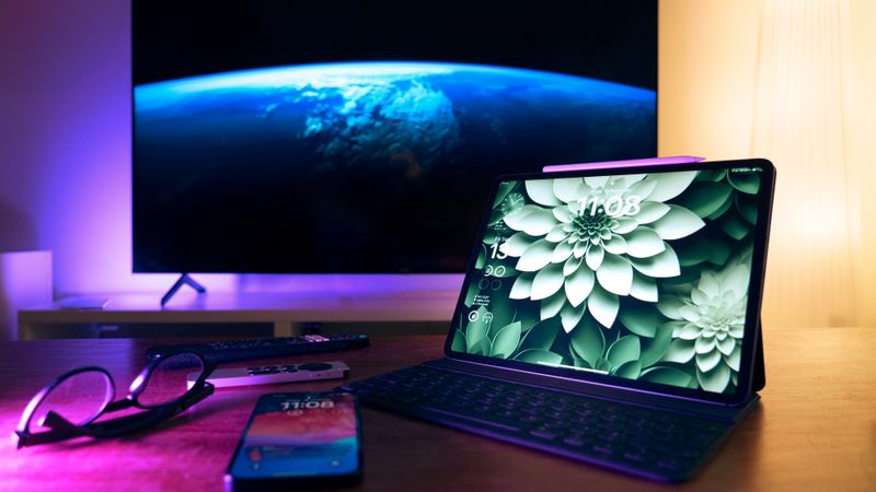 Stylish home office setup featuring devices like tablet, smartphone, and large screen display.