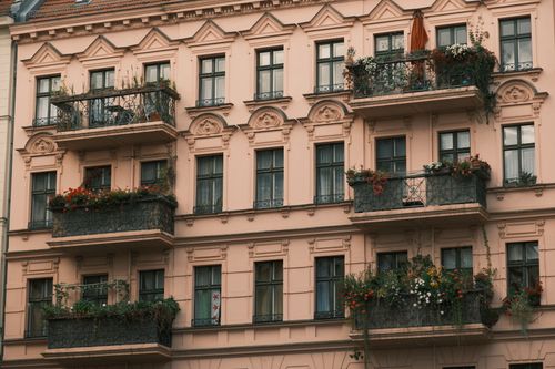 Free A detailed view of a European-style apartment building with ornate balconies decorated with plants. Stock Photo