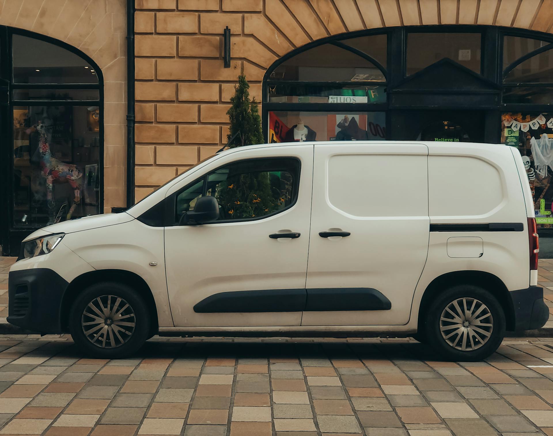 A plain small white van parked at the side of the road
