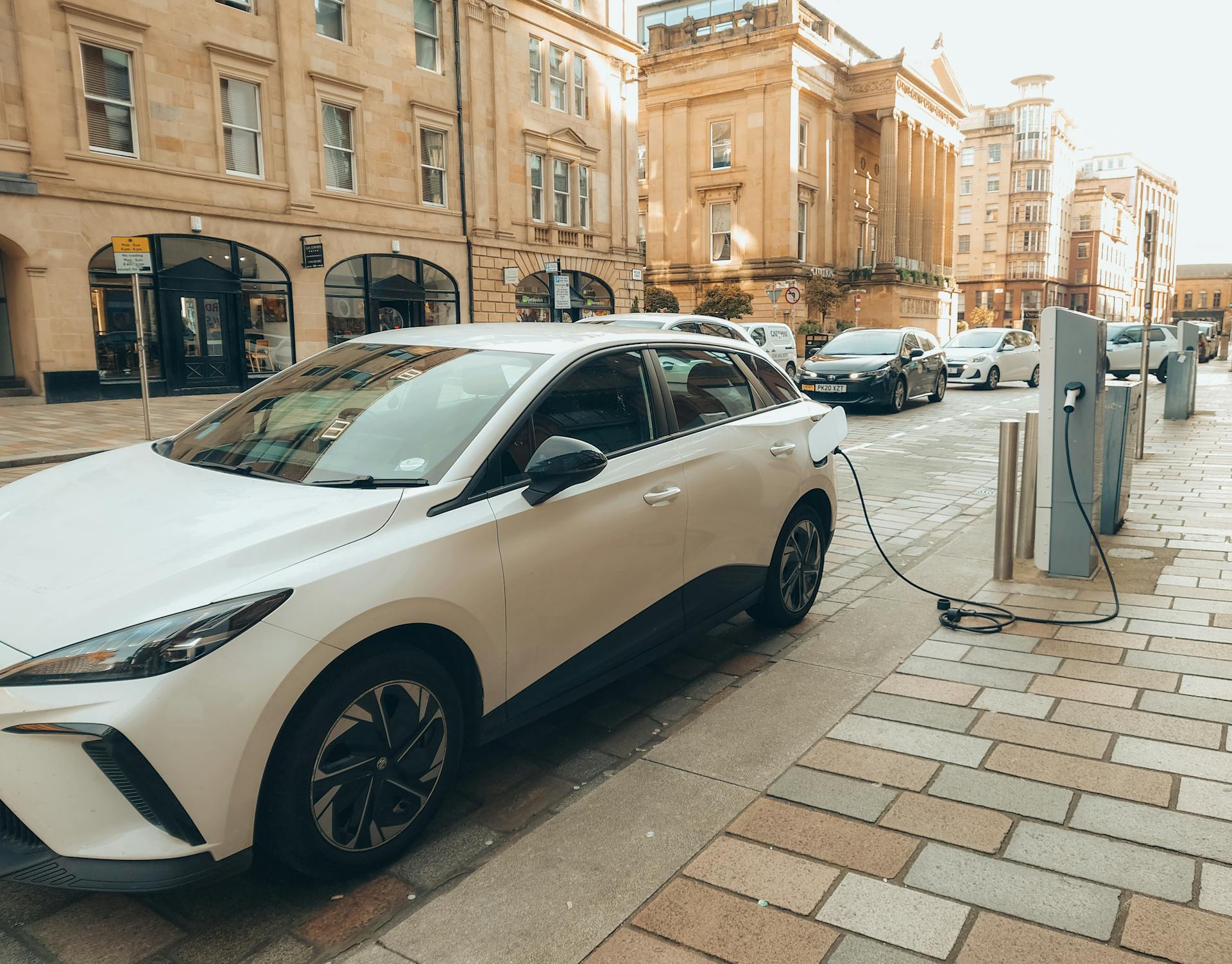 A small electric car plugged in to a charging station