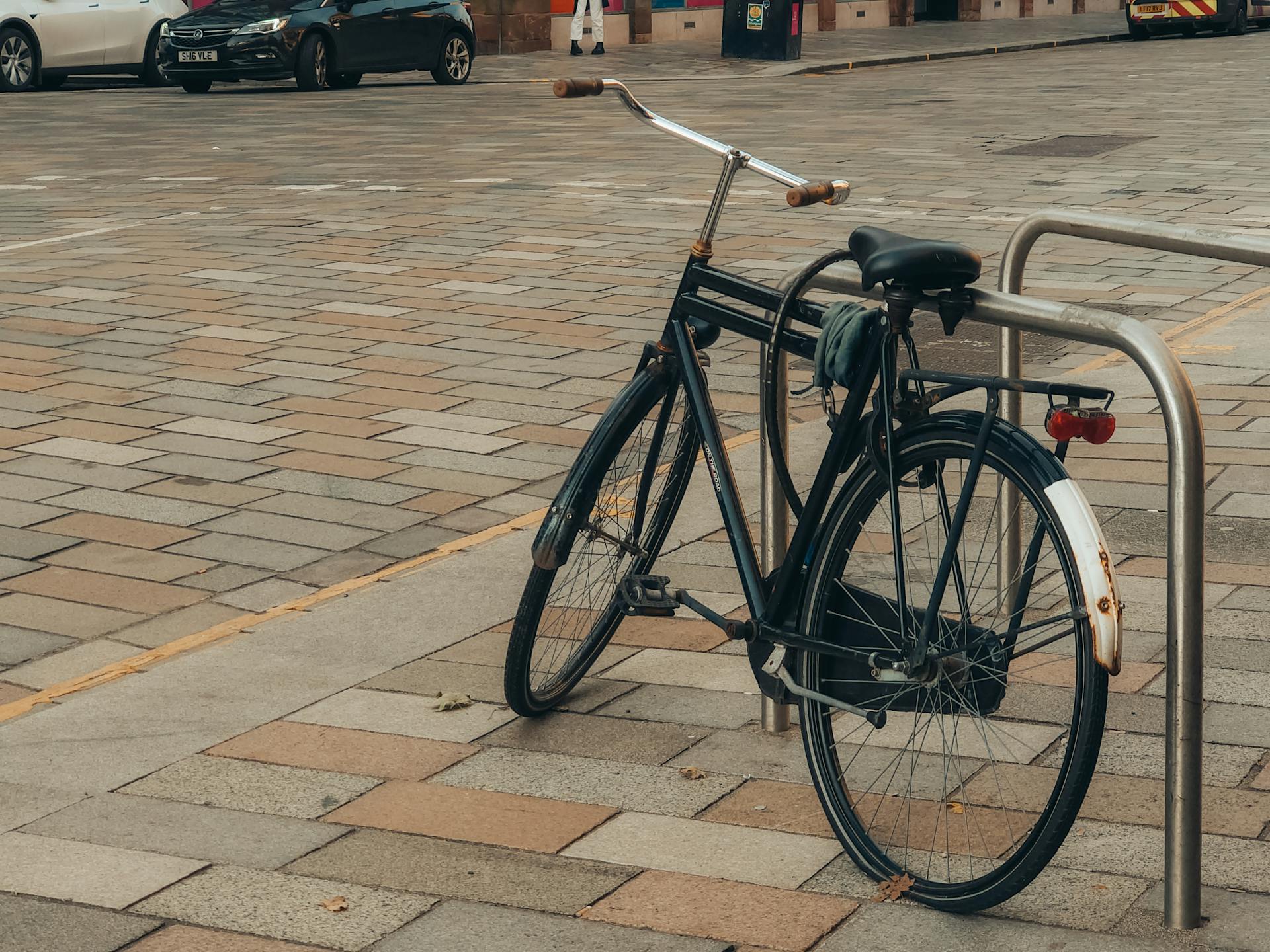 A bicycle secured to a stand on a city street