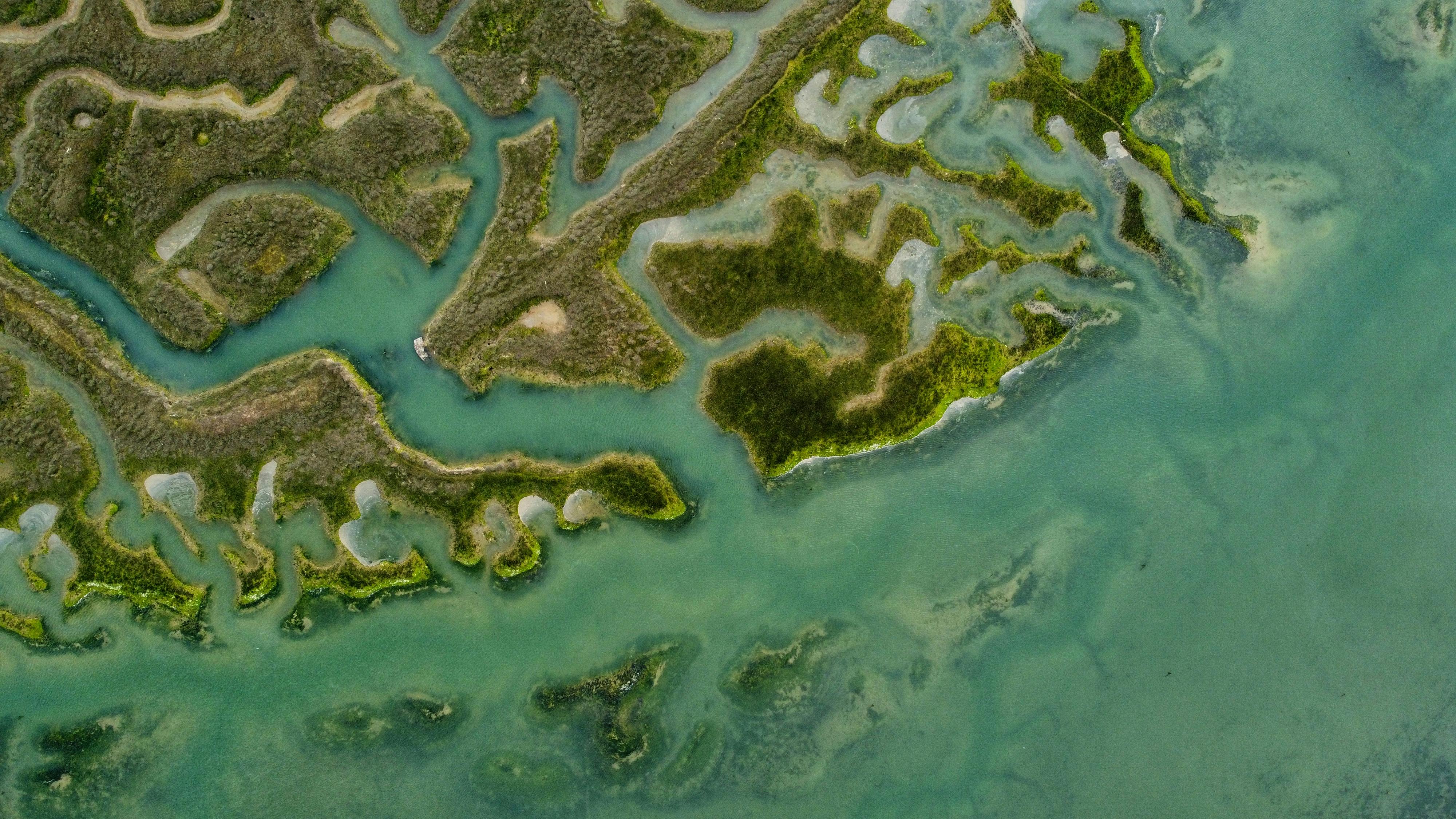 Stunning aerial view of the lush green and blue coastal marshlands in Saint-Suliac, Bretagne, France.