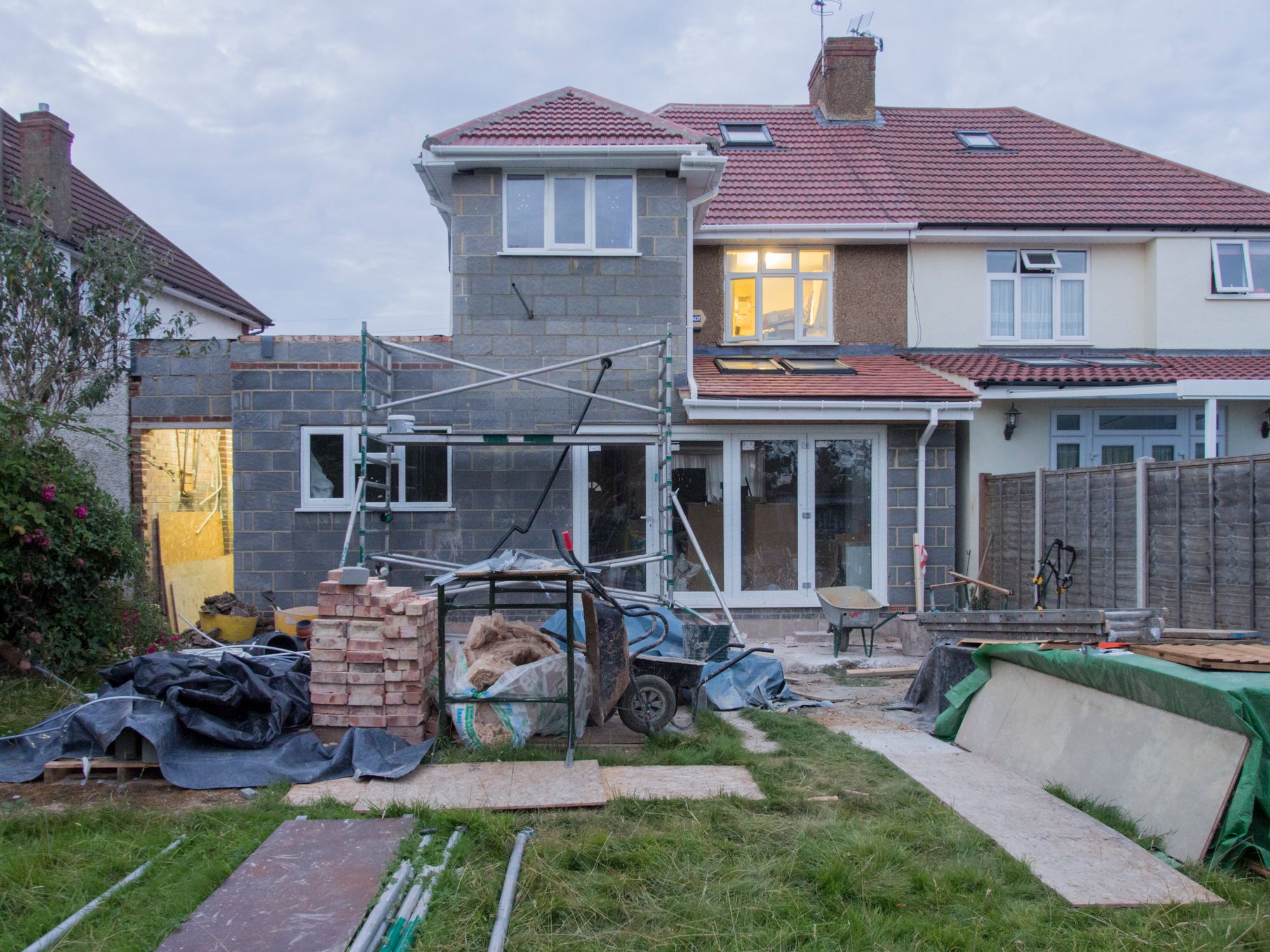Suburban house undergoing renovation with scaffolding and building materials