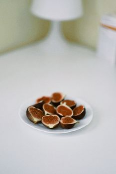 Sliced figs on a minimalist white plate, evoking a serene and modern feel.