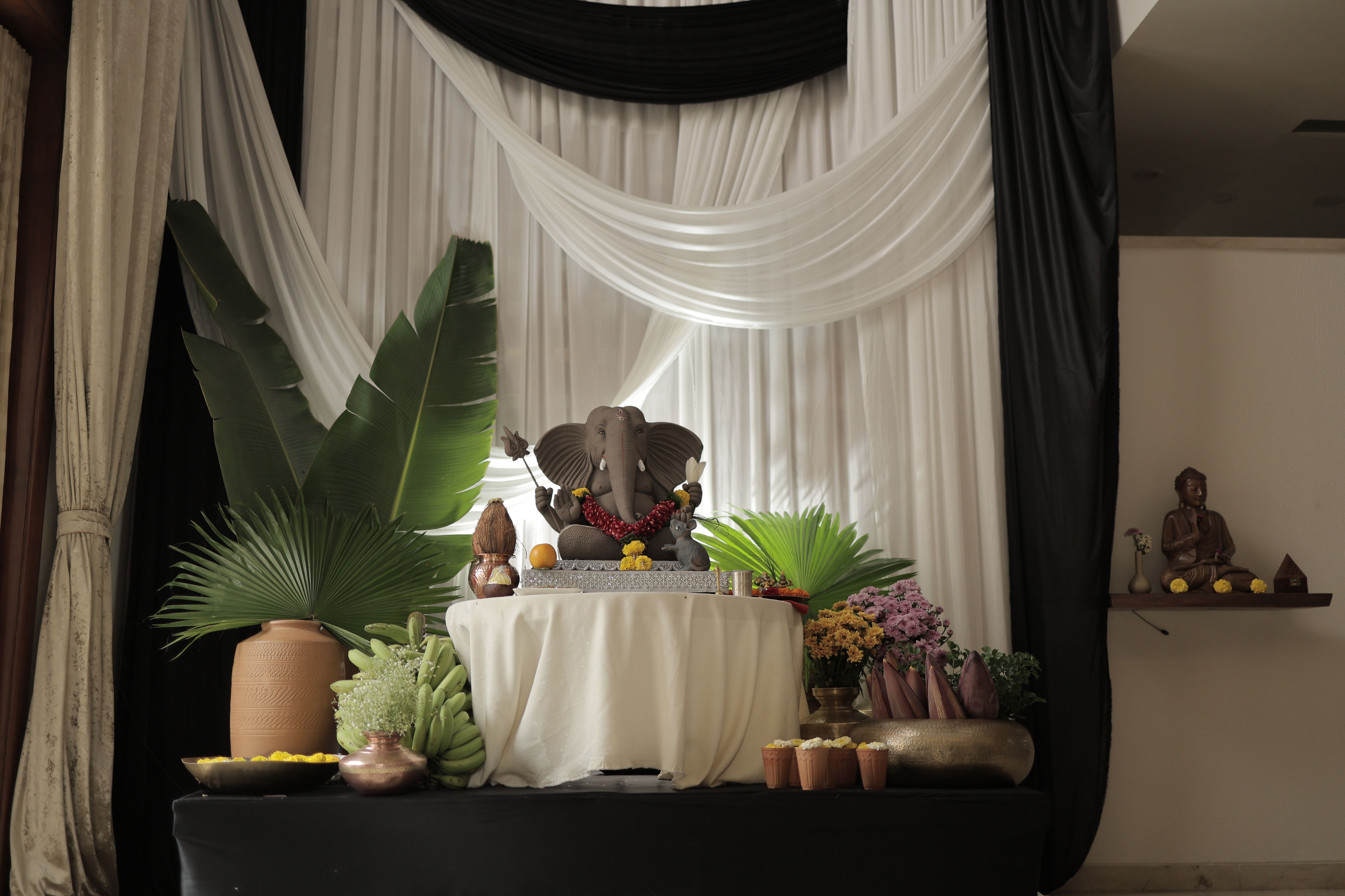 Altarde decorada com flores, plantas e uma estátua de Ganesha, símbolo de prosperidade, geralmente usada em celebrações tradicionais indianas.