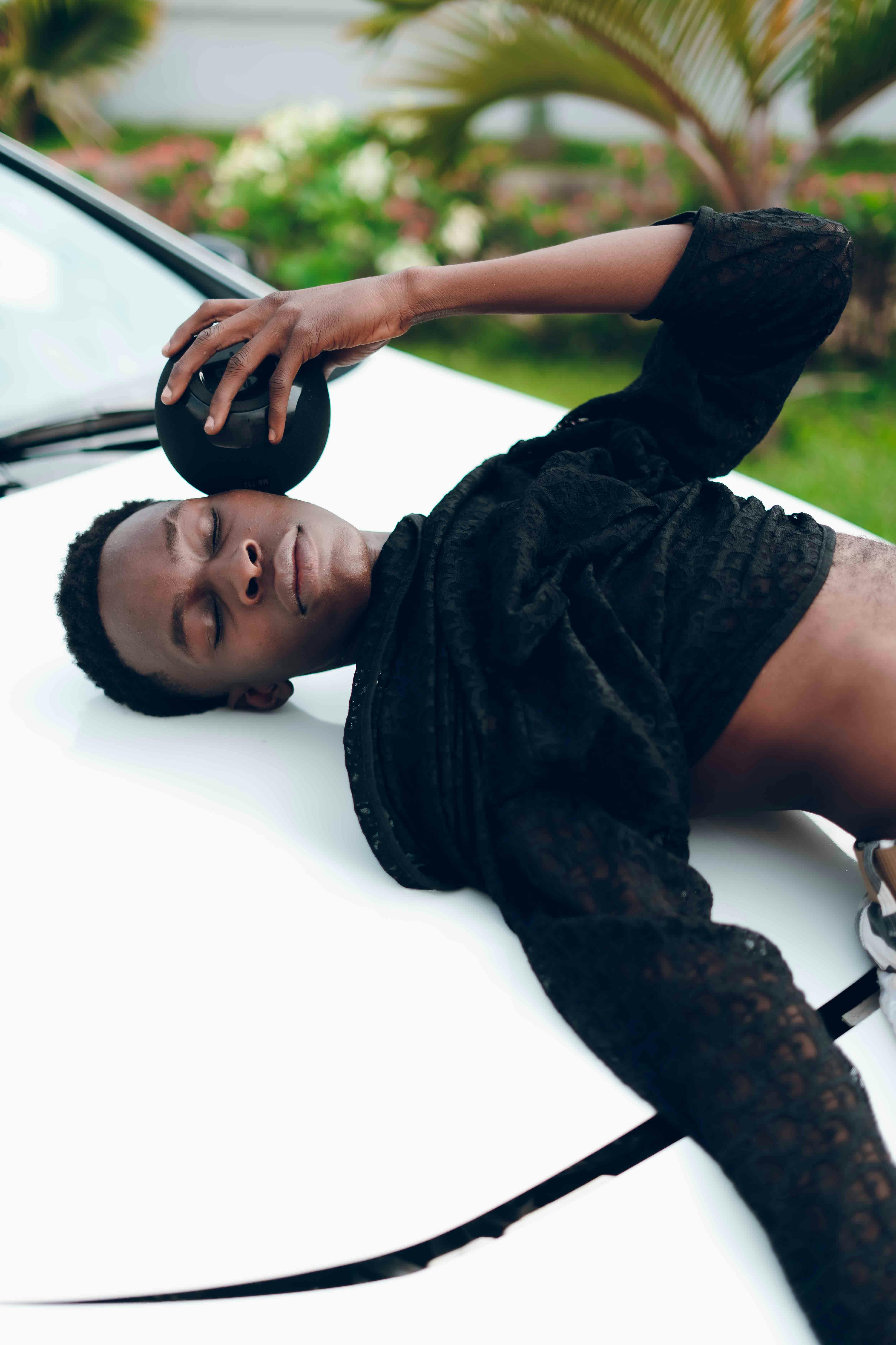 contemporary fashion pose on a white car in nigeria