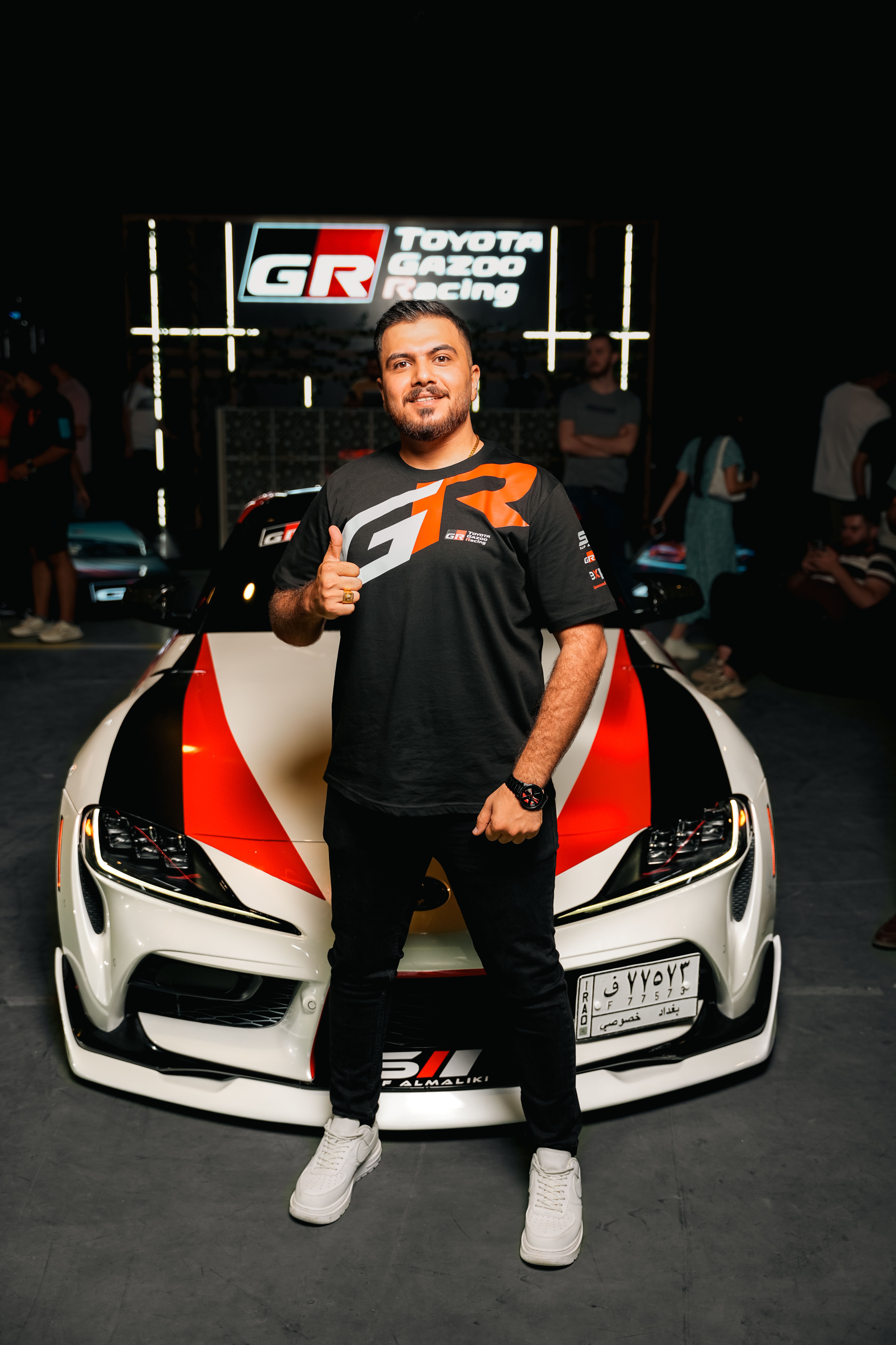 Man Posing with Toyota Racing Car at Event · Free Stock Photo