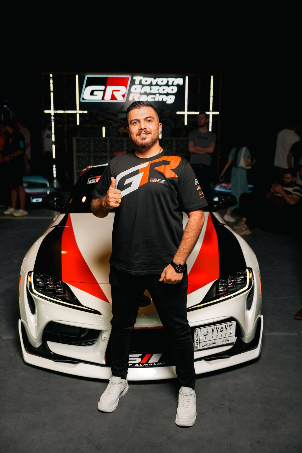 Man Posing with Toyota Racing Car at Event · Free Stock Photo
