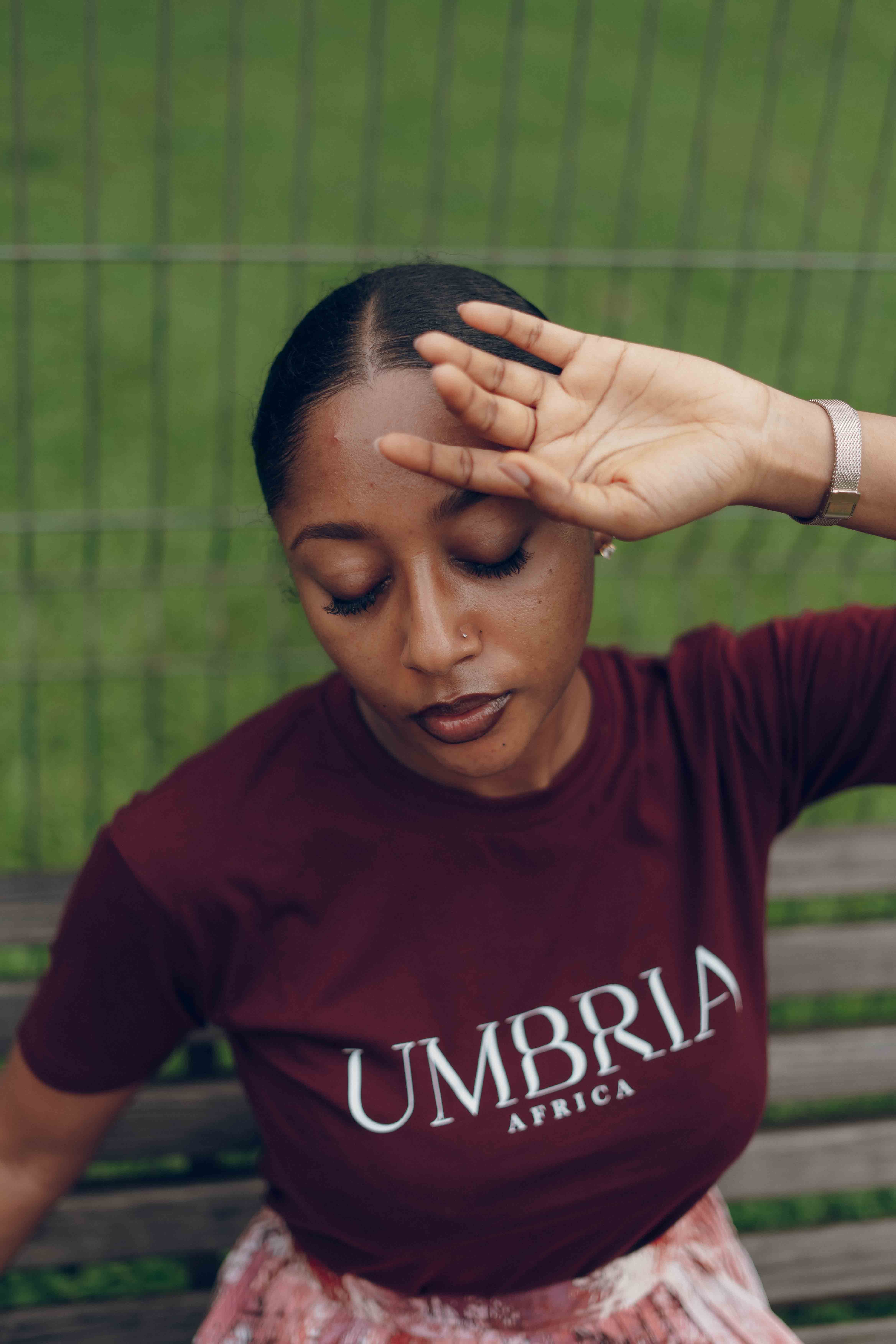 Stylish African woman posing outdoors in Nigeria wearing Umbria Africa shirt.