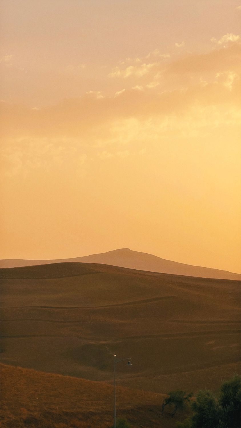 Serene Sunset Over Rolling Hills Landscape · Free Stock Photo