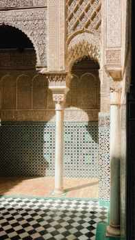 Ornate archway with geometric tiles in Moorish-style architecture, bathed in sunlight.