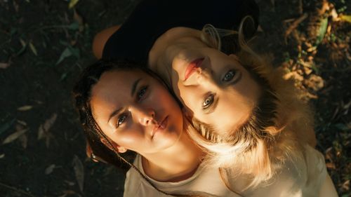 Free Overhead portrait of two women lying outdoors, showcasing diversity and friendship. Stock Photo