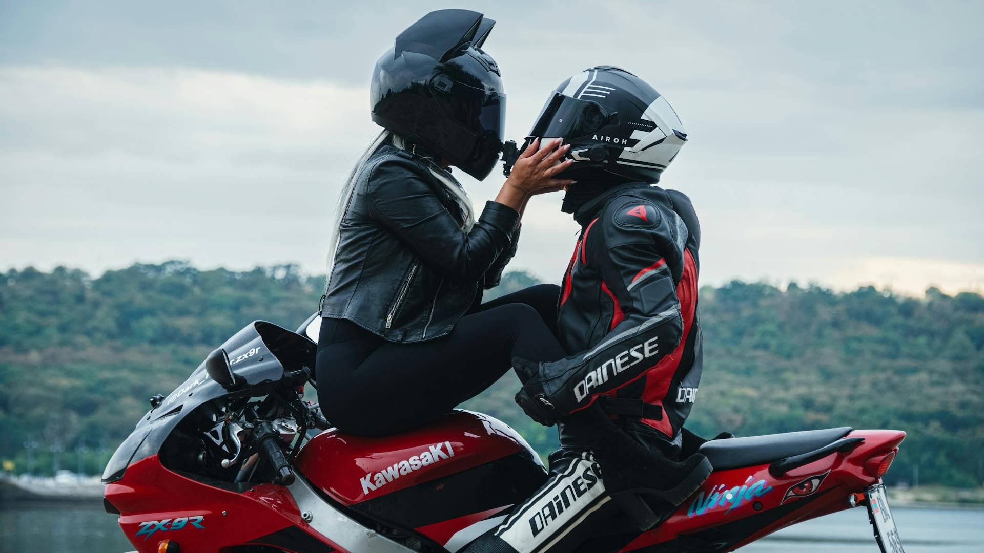 Couple on Motorcycle with Helmets Near Scenic View