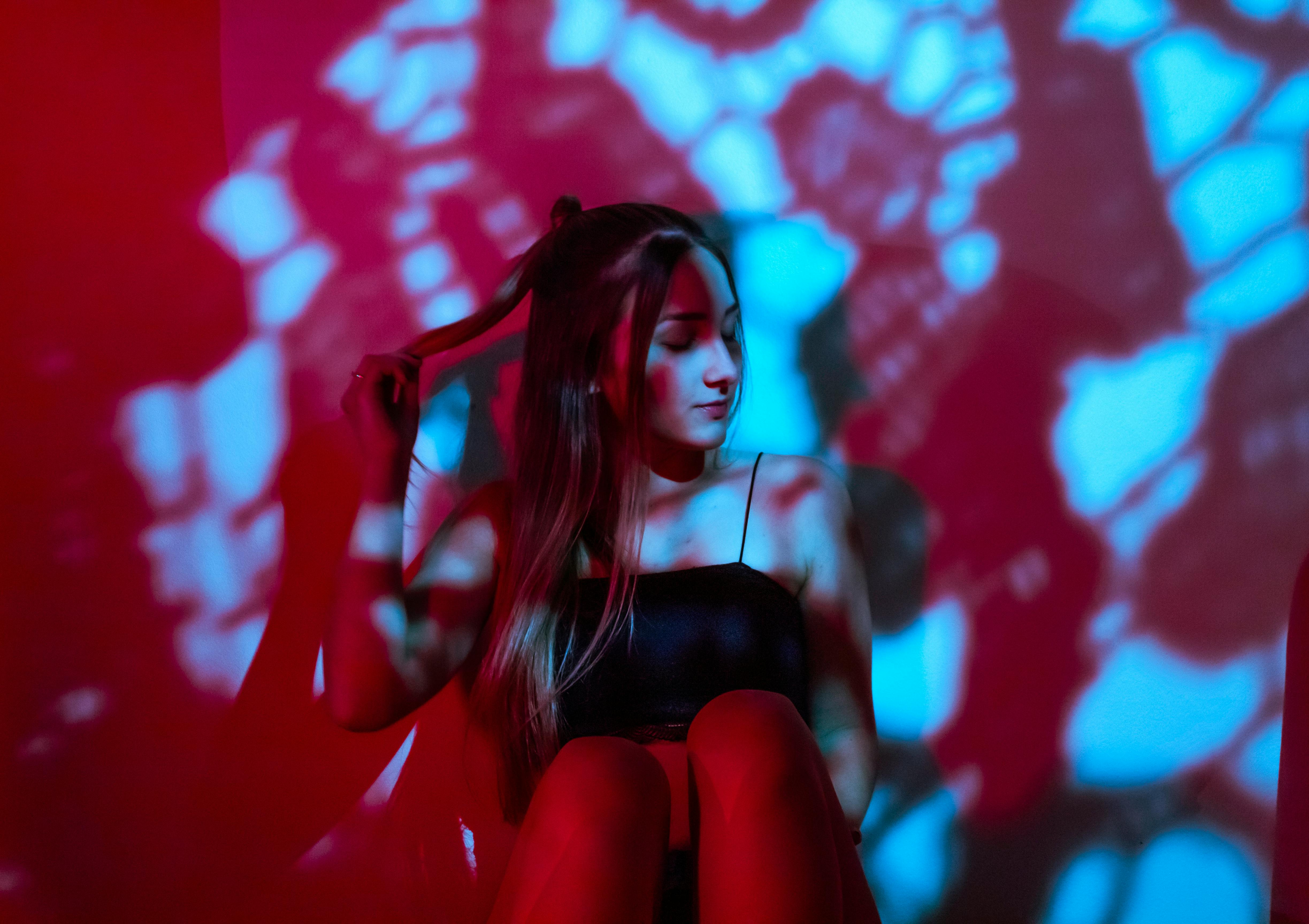 一位长发女士在动态的红蓝灯光下摆出艺术姿势