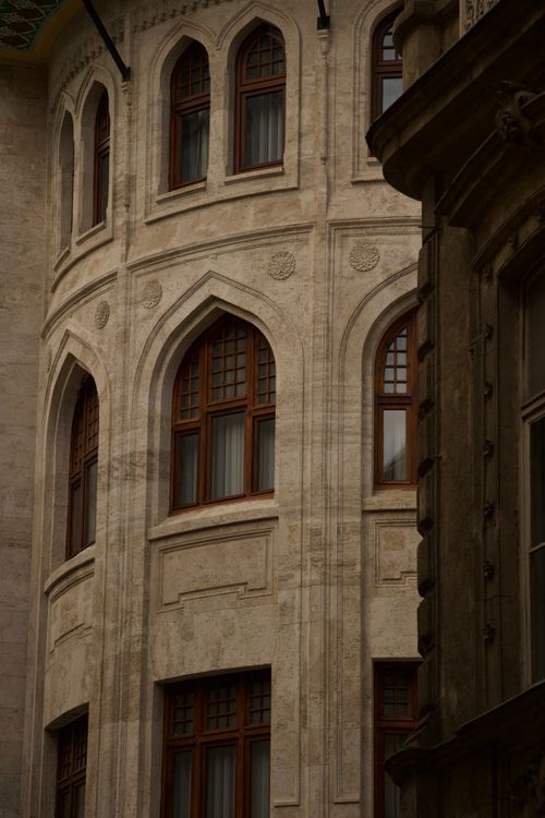 Free Close-up of a gothic-style building facade with decorative arches and windows. Stock Photo