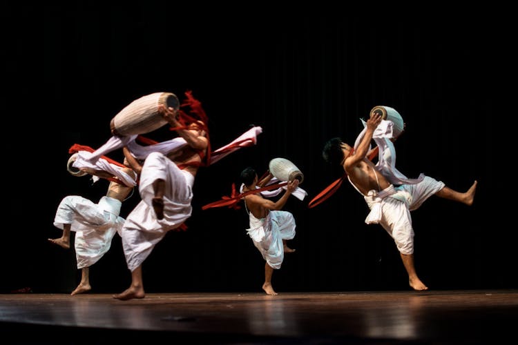 Group Of Men Holding Drums Performing On Stage