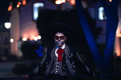 Free Catrin in traditional makeup and attire celebrating Day of the Dead in Puebla, Mexico at night. Stock Photo