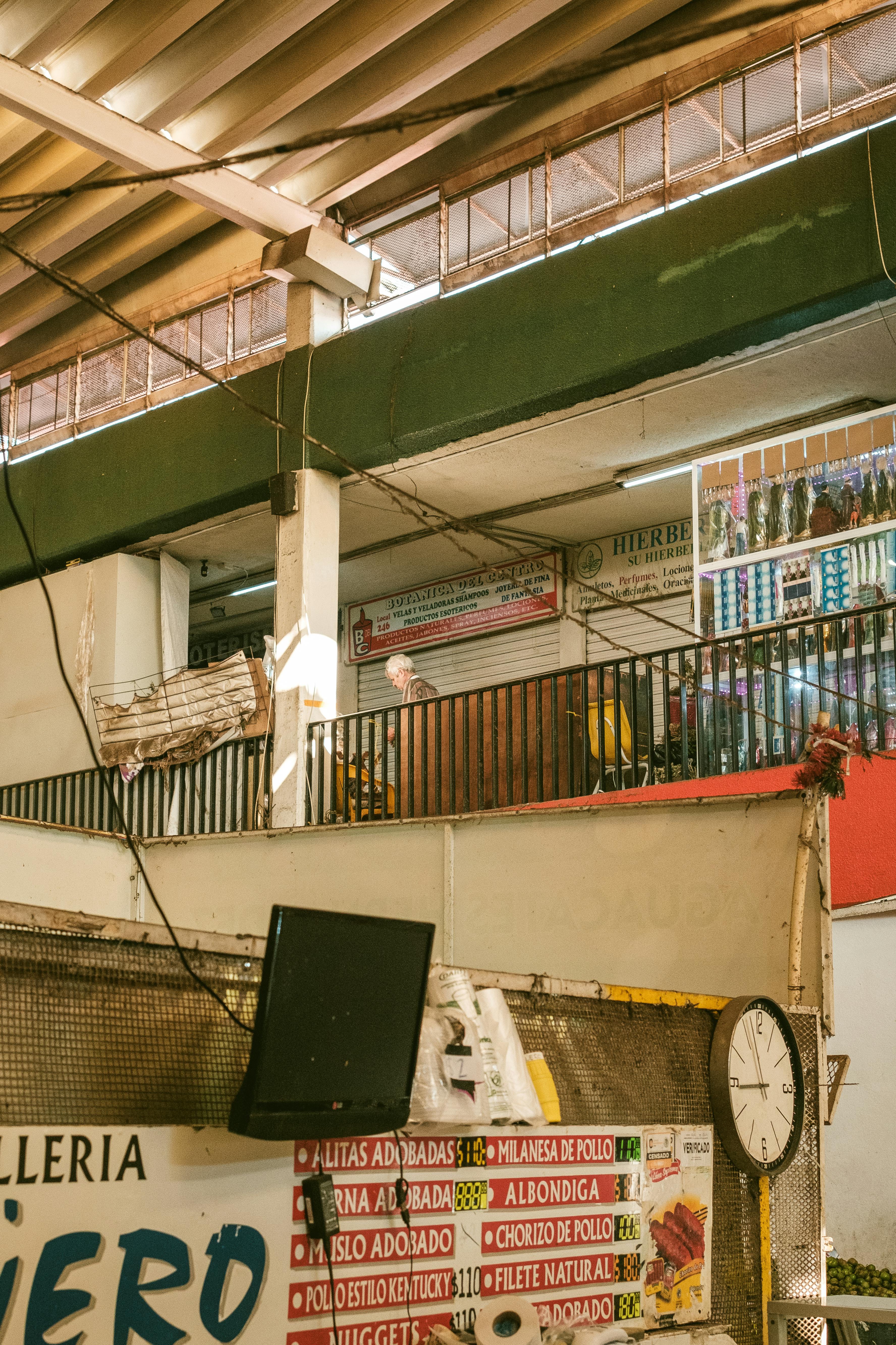 Vibrant indoor market scene with various food stalls and signage, capturing the lively atmosphere.
