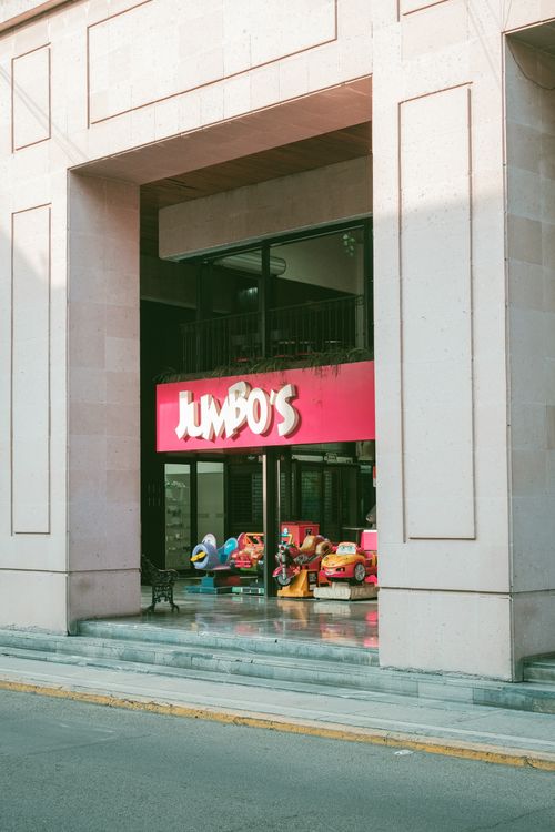 Free Exterior view of Jumbo's toy store entrance with colorful kiddie rides. Stock Photo